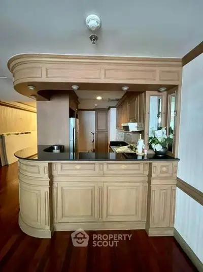 Elegant kitchen with wooden cabinetry and black countertops in a stylish home interior.
