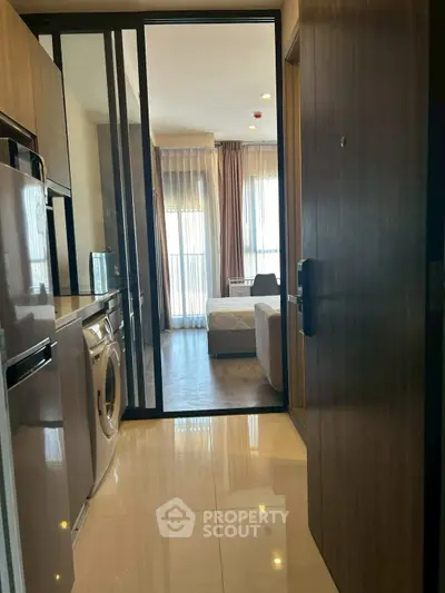 Modern apartment entrance with kitchen and bedroom view