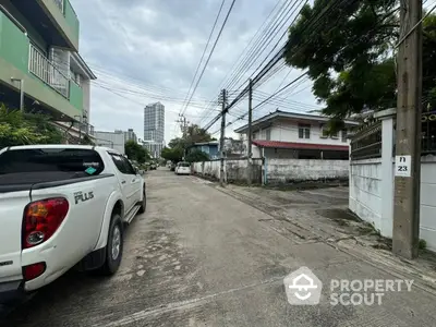 Charming urban street view with residential buildings and parked vehicles, showcasing a peaceful neighborhood vibe.