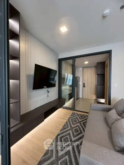 Modern living room with sleek design and wall-mounted TV in a stylish apartment.