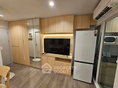 Modern living room with sleek wooden cabinetry and integrated appliances