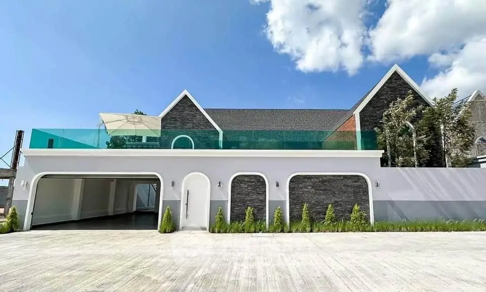 Stunning modern home with sleek design and spacious garage under clear blue skies.