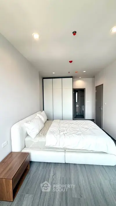 Modern bedroom with sleek design, featuring a comfortable bed and ample closet space, perfect for relaxation.