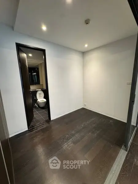 Spacious room with dark wood flooring and attached bathroom
