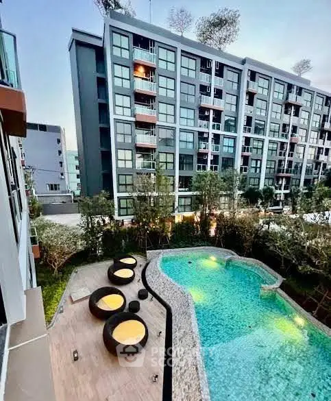 Modern apartment building with stylish pool and outdoor seating area, perfect for urban living.