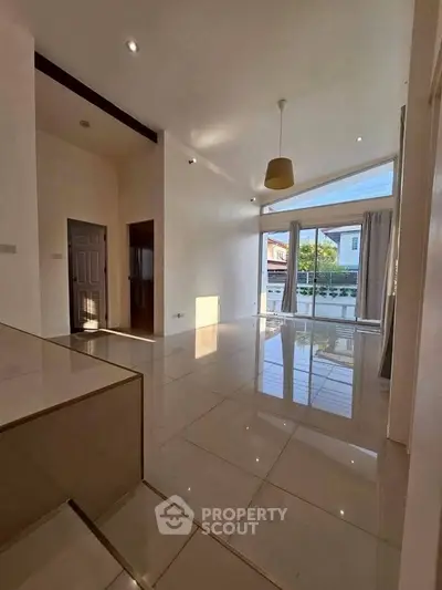 Spacious modern living room with high ceilings and large windows offering abundant natural light.