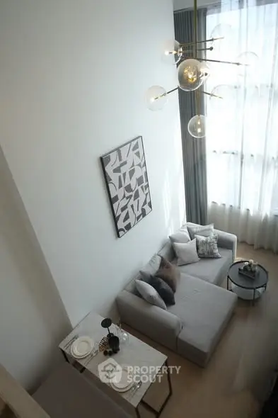 Modern living room with high ceiling and stylish decor in a contemporary apartment.