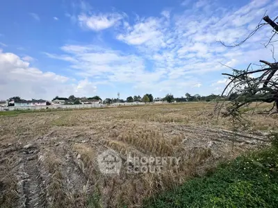 Expansive land plot with clear blue sky, ideal for development opportunities.