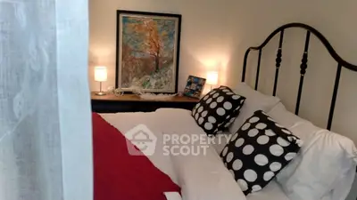 Cozy bedroom with stylish decor and modern art, perfect for relaxation.