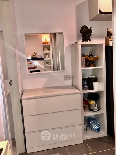 Modern storage area with sleek white drawers and open shelving in a stylish home interior.