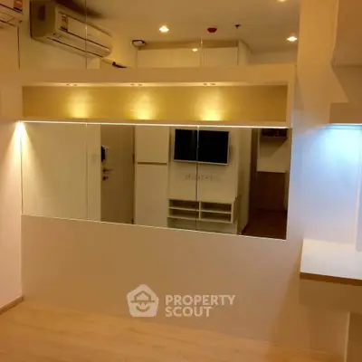 Modern interior with mirrored wall and built-in air conditioning, showcasing sleek design and efficient use of space.