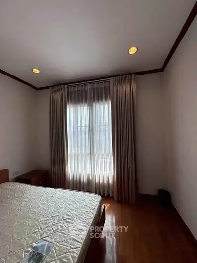 Cozy bedroom with natural light and elegant curtains, perfect for relaxation.