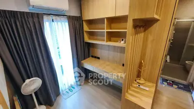 Modern study room with built-in wooden shelves and desk, air conditioning, and natural light.