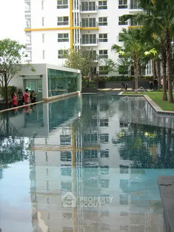 Luxurious apartment complex with a stunning outdoor pool and lush greenery.