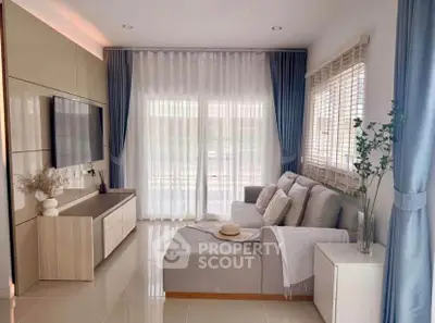 Modern living room with elegant decor, large windows, and cozy seating area.