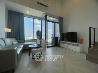 Modern living room with large windows and city view, featuring stylish furniture and a cozy atmosphere.