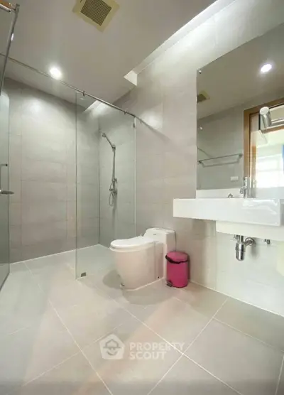Modern bathroom with glass shower and sleek fixtures in a contemporary home.