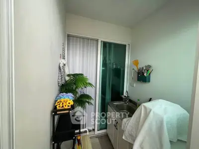 Compact laundry area with sink and storage in modern apartment