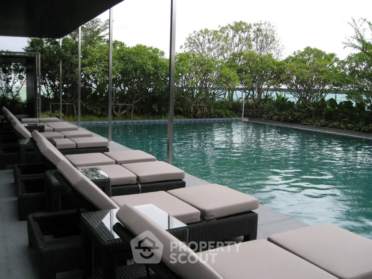 Luxurious outdoor pool area with stylish seating and lush greenery, perfect for relaxation and leisure.