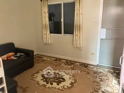 Cozy living room with patterned rug and sofa, ideal for relaxation.