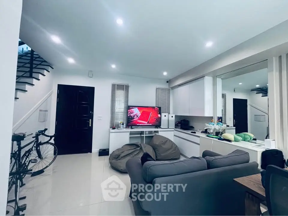 Modern living room with sleek design, featuring a cozy sofa, TV, and stylish decor.