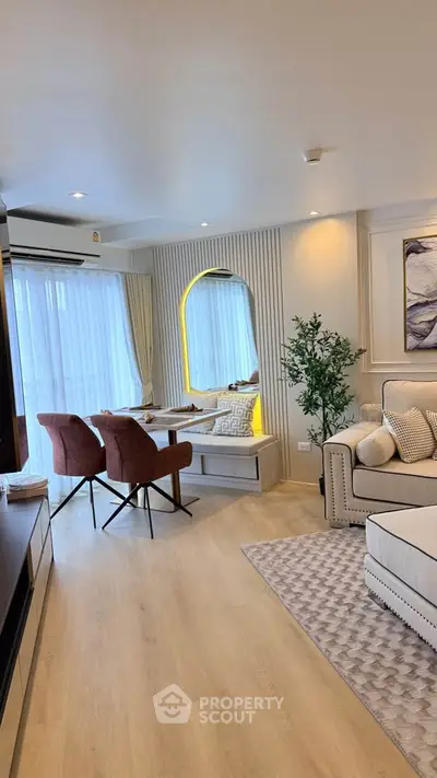 Elegant living room with modern decor and cozy seating area, featuring stylish lighting and large windows.