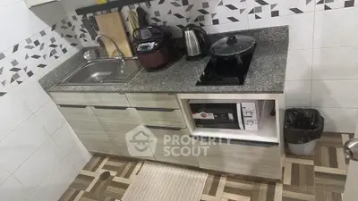 Modern kitchen with sleek countertop and appliances, featuring a stylish backsplash.