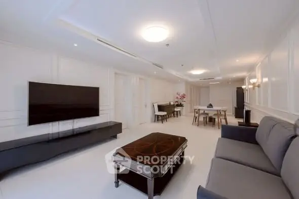 Spacious modern living room with elegant furniture and large TV, perfect for relaxation.