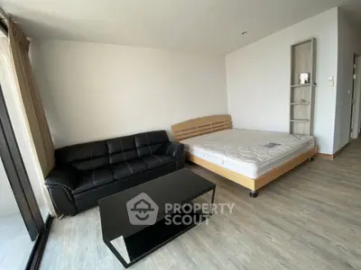 Modern studio apartment with sleek black sofa and minimalist decor