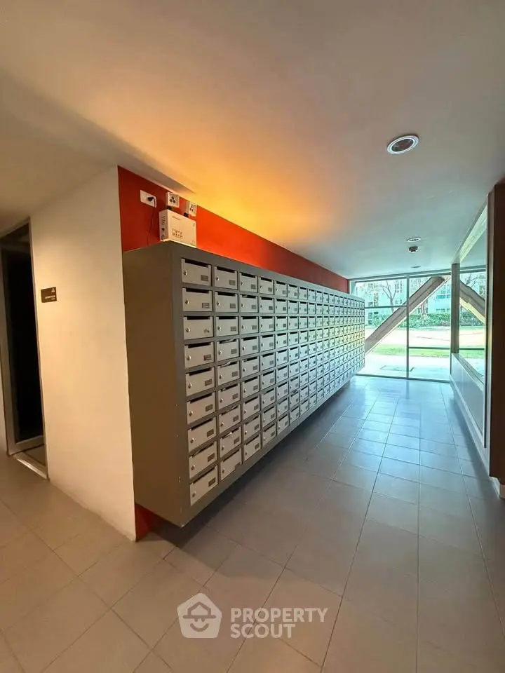 Modern apartment building mailroom with sleek design and ample natural light.