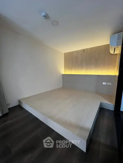 Modern minimalist bedroom with elevated platform and ambient lighting