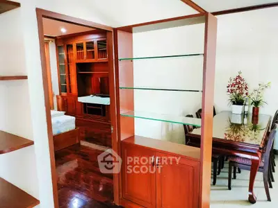 Spacious living area with elegant wooden furniture and built-in shelving, perfect for modern living.