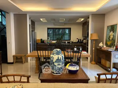 Elegant open-layout living and dining area with stylish decor and modern kitchen.