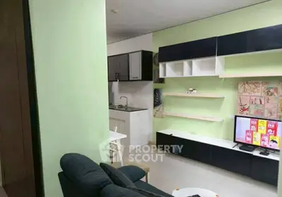 Modern living room with sleek entertainment unit and compact kitchen area.