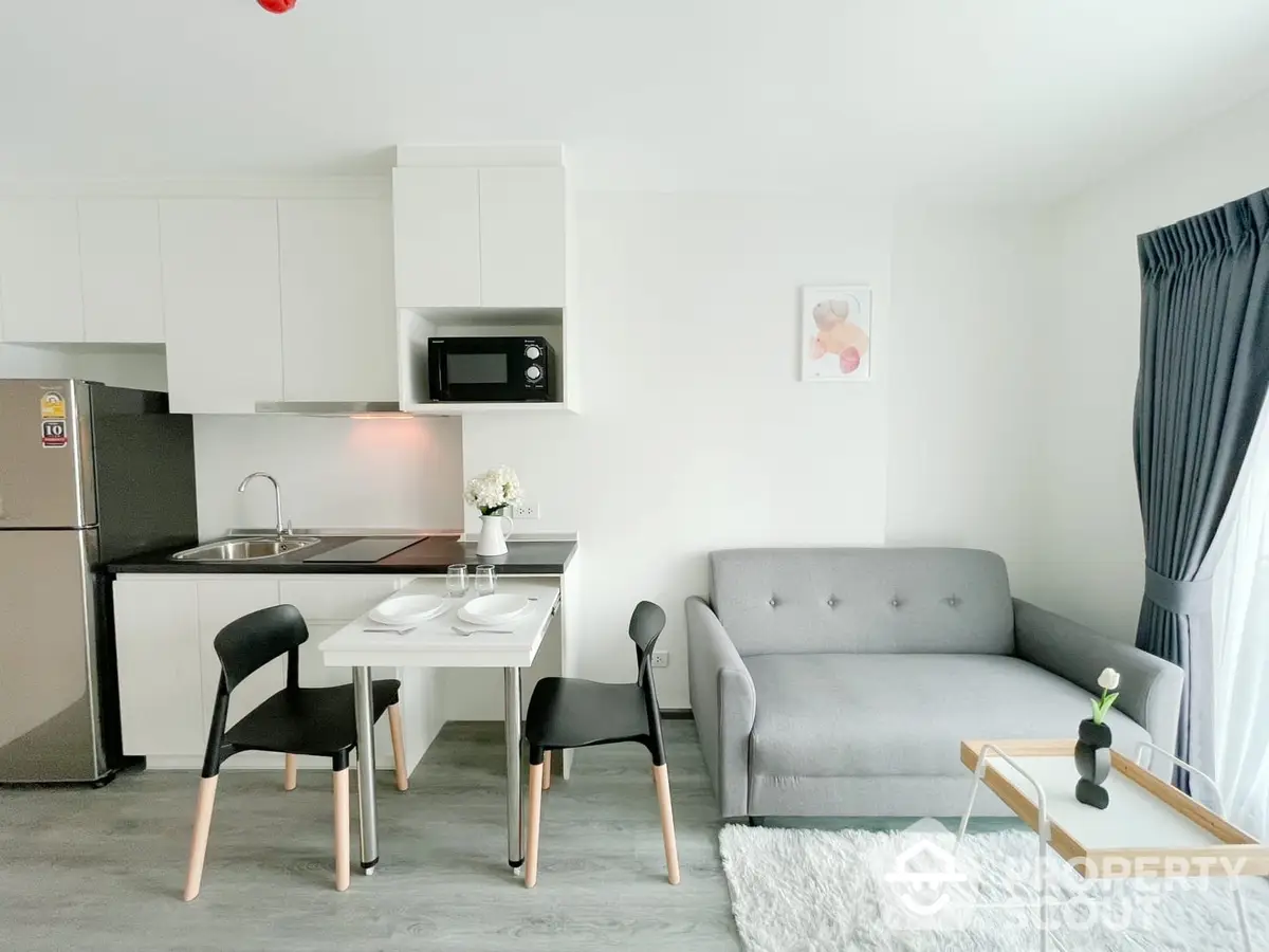 Chic studio apartment with integrated living and kitchen space, featuring modern furniture, stainless steel appliances, and a cozy dining area.