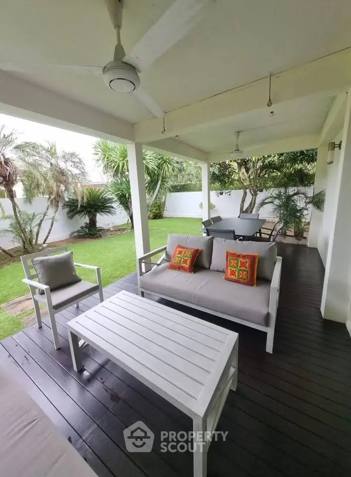 Spacious outdoor patio with stylish seating and lush garden view, perfect for relaxation and entertainment.