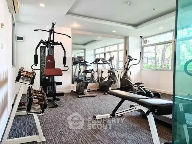 Modern gym with state-of-the-art fitness equipment and large windows for natural light.