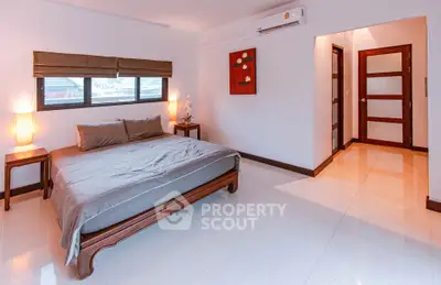 Spacious bedroom with modern decor and natural light in a stylish home.