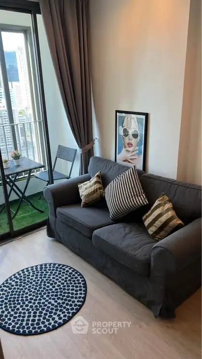 Chic urban living room with balcony view, modern decor, and cozy seating in a high-rise apartment.