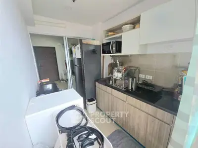 Compact kitchen with modern appliances and washing machine in cozy apartment