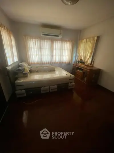Cozy bedroom with natural light and air conditioning, perfect for relaxation.