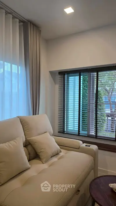 Cozy living room with plush sofa and large windows offering natural light