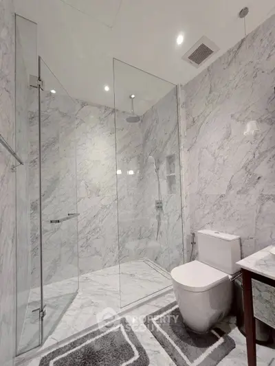 Luxurious marble bathroom with glass shower and modern fixtures