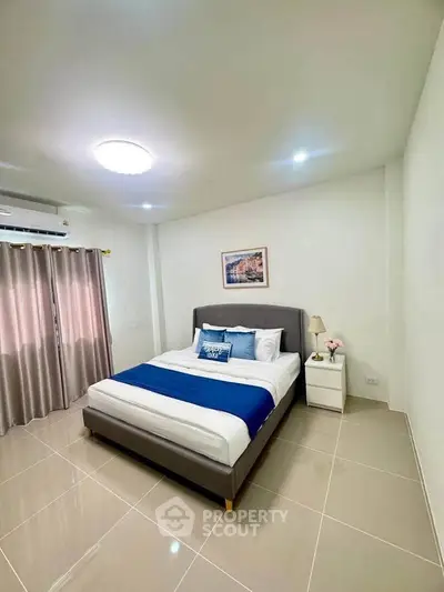 Modern bedroom with stylish decor and natural light, featuring a comfortable bed and elegant curtains.