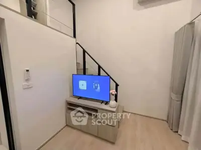 Modern living room with sleek TV setup and minimalist decor in a stylish apartment.