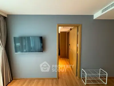 Modern living room with wall-mounted TV and wooden flooring