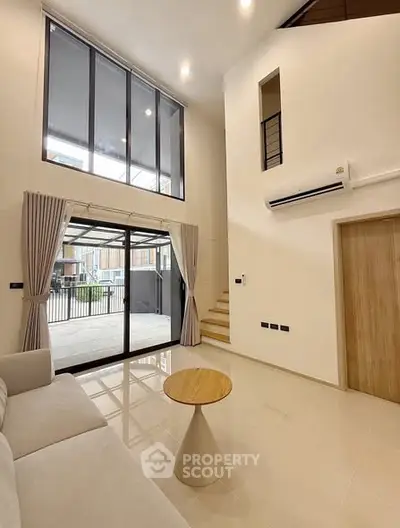 Spacious modern living room with high ceilings and large windows