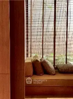 Cozy window seating area with wooden blinds and plush cushions in a modern home.