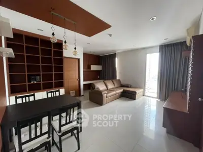 Modern living room with sleek furniture and open layout, featuring a cozy sofa and dining area.