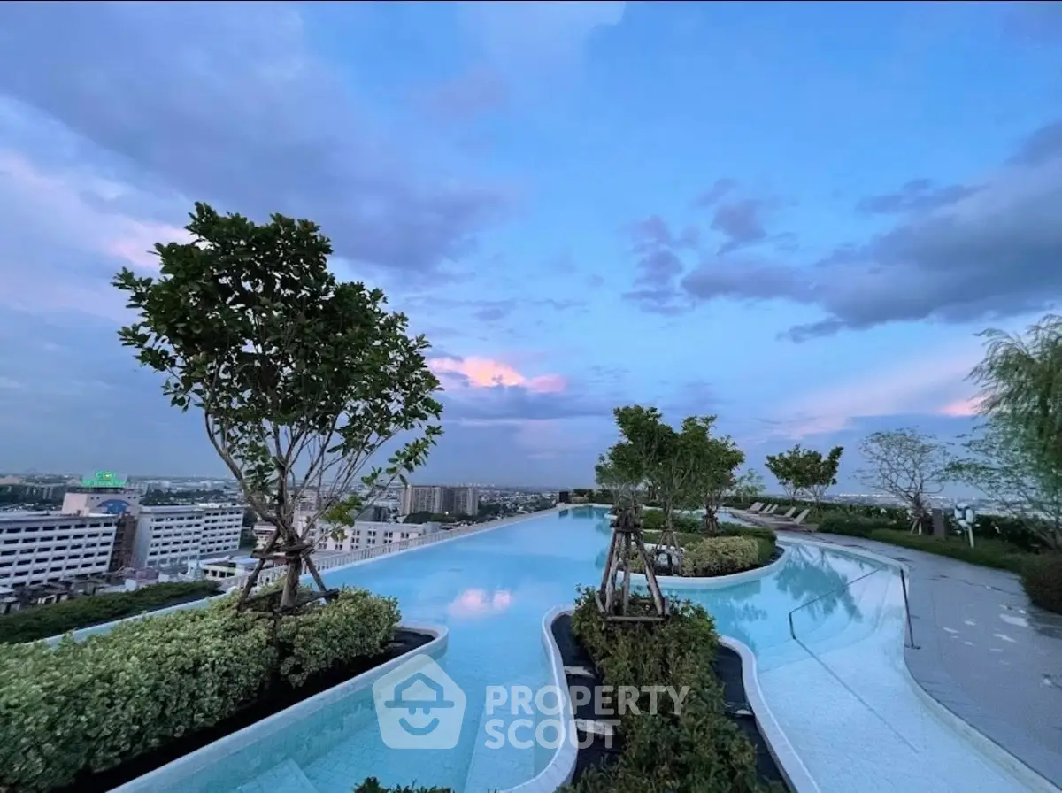 Stunning rooftop infinity pool with panoramic city views at sunset.
